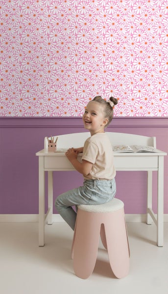Kinderzimmer mit Blumentapete, Schreibtisch und Hocker für Kinder.