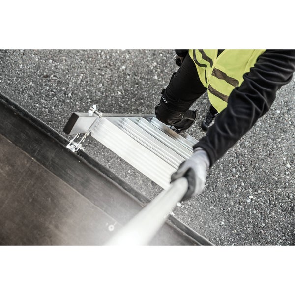 Person steigt auf eine Aluminiumleiter mit Anlegevorrichtung