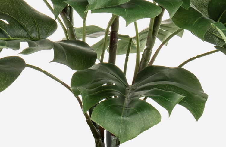 Künstlicher Zweig mit grünen Blättern und rosa-weißen Blüten.