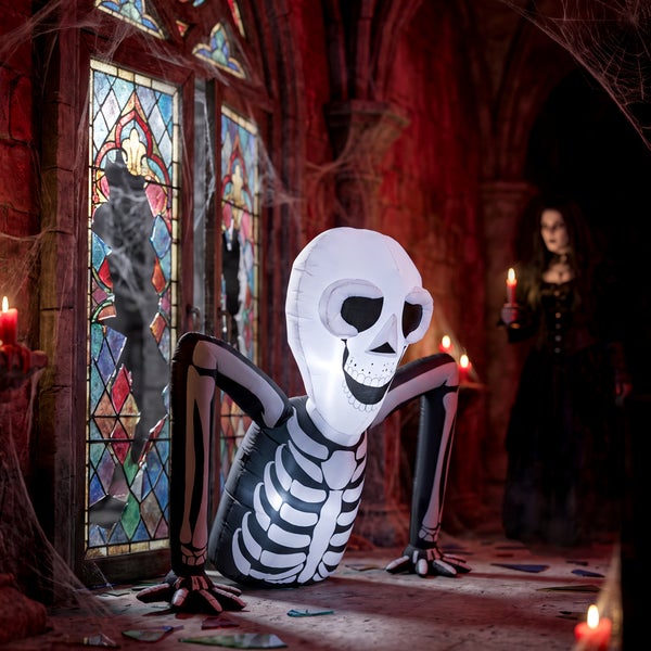 Aufblasbares Skelett als Halloween Dekoration für Innen und Außen in einer gruseligen Kulisse mit Buntglasfenstern und Kerzenschein.