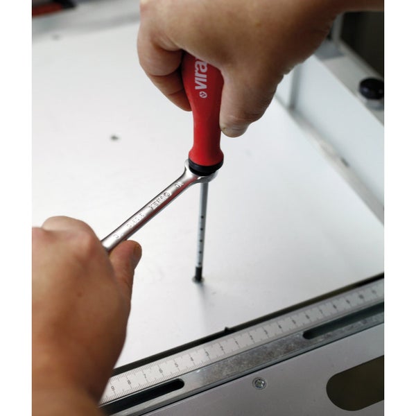 Eine Person benutzt einen Schraubendreher und einen Schraubenschlüssel an einem Werkstück.