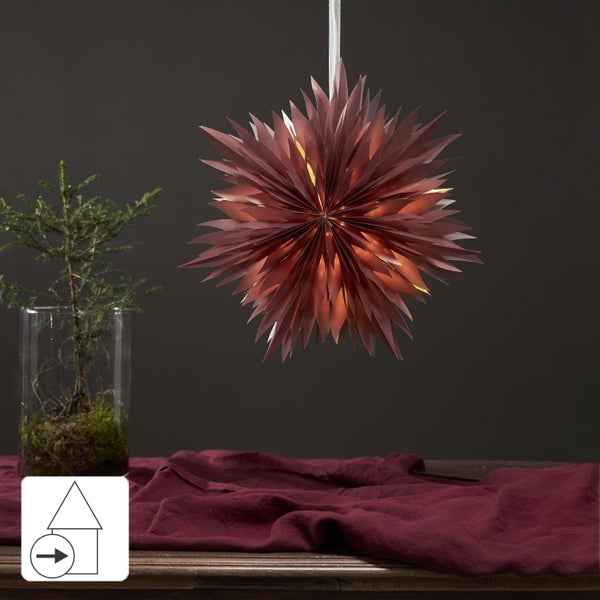 Dekoratives Arrangement mit Papiersternleuchte, Glasvase mit Pflanze und Stofftuch auf einem Tisch.