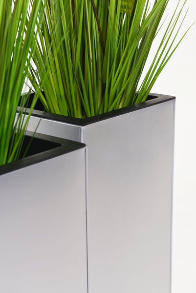 Zwei hohe, silberfarbene quadratische Pflanzkübel mit künstlichem grünem Gras.