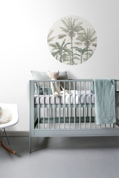 Kinderzimmer mit Gitterbett, Wandtattoo und Schaukelstuhl