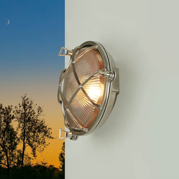 Wandleuchte aus Metall mit Schutzgitter und Leuchtmittel an der Wand