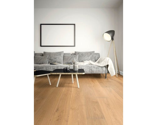 Wohnzimmer mit Holzboden, Sofa und Stehlampe