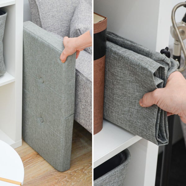 Hand verstaut eine zusammengefaltete graue Aufbewahrungsbox aus Stoff und deren Deckel platzsparend in einem weißen Regal.