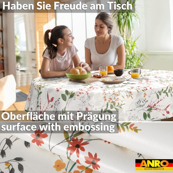 Runde Tischdecke mit Blumenmuster auf einem Esstisch in einem hellen Raum. Detailansicht der geprägten Oberfläche des Materials. ANRO Logo.