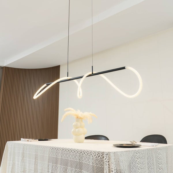 Moderne schwarze Pendelleuchte mit geschwungenem LED-Schlauch über einem gedeckten Esstisch in einem hellen, modernen Esszimmer.