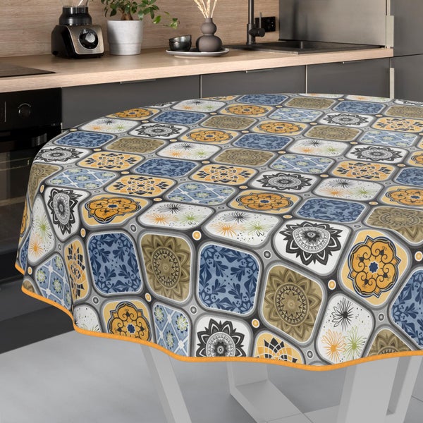 Runde Tischdecke mit dekorativem Fliesenmuster und floralen Motiven auf einem Küchentisch.