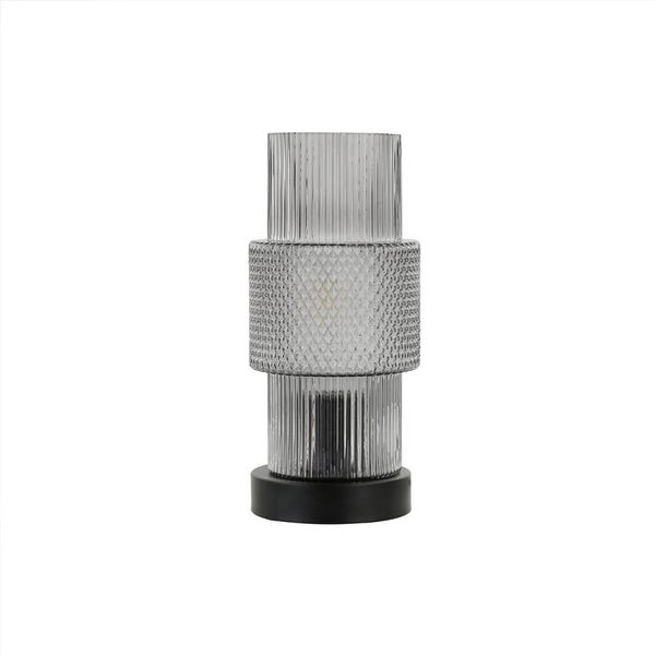 Dekorative Tischleuchte aus Glas mit geriffeltem Design und schwarzem Sockel.