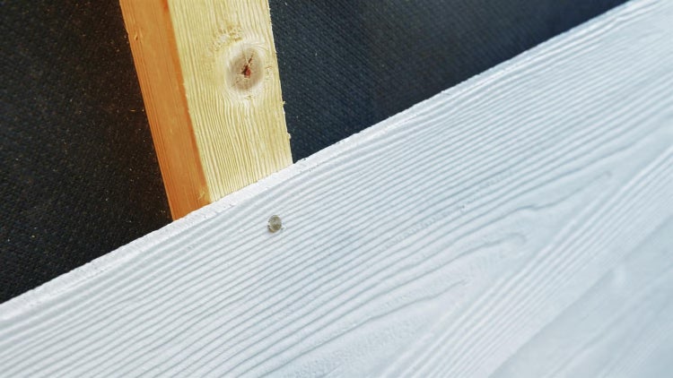 Fassadenverkleidung aus Faserzement in Holzoptik montiert auf einer hölzernen Unterkonstruktion mit schwarzer Dämmbahn