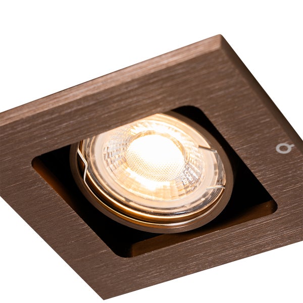 Quadratischer LED Einbaustrahler aus gebürstetem Metall mit eingeschaltetem warmweißem Licht.