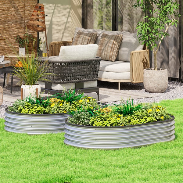 Ovale Hochbeete aus Wellblech auf einer Rasenfläche in einem modern gestalteten Garten mit Loungemöbeln und Pflanzen.
