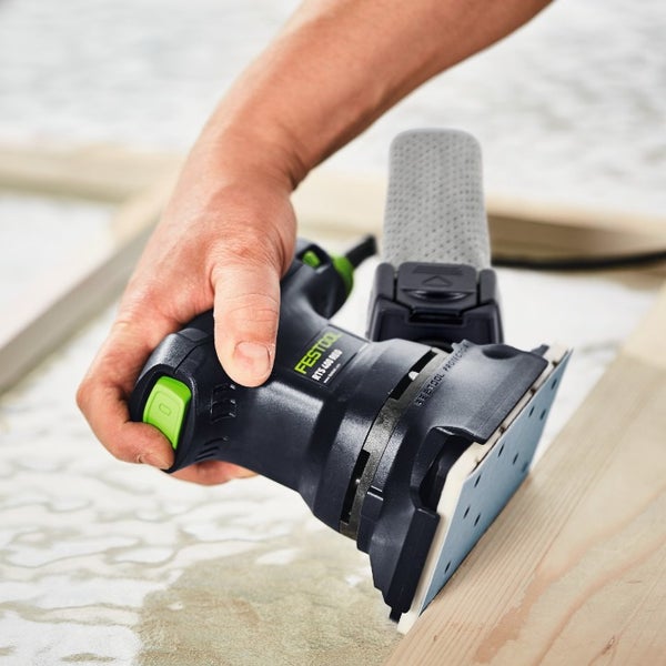 Hand führt einen Festool Rutscher RTS 400 REQ bei der Bearbeitung eines Holzrahmens mit montiertem Staubsack.
