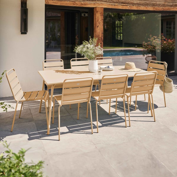 Modernes Gartenmöbel-Set bestehend aus einem rechteckigen Esstisch aus Metall und passenden Lamellenstühlen auf einer hellen Terrasse.
