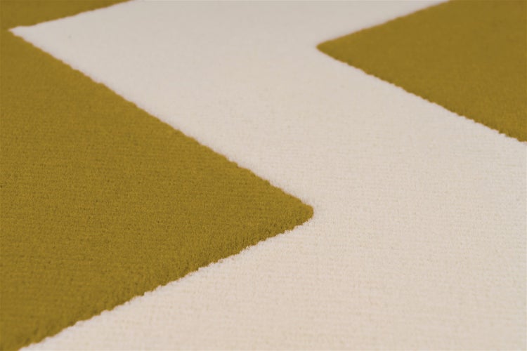 Detailansicht eines Teppichs mit geometrischem Zickzackmuster aus strukturiertem Textilgewebe.