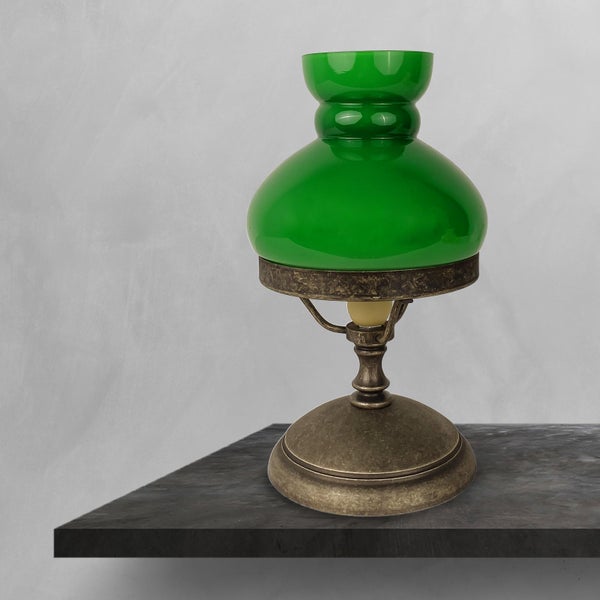 Tischlampe mit grünem Glasschirm auf einem Tisch