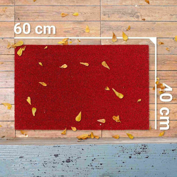 Roter Fußabtreter vor einer Tür mit einem Paar Gummistiefel darauf.