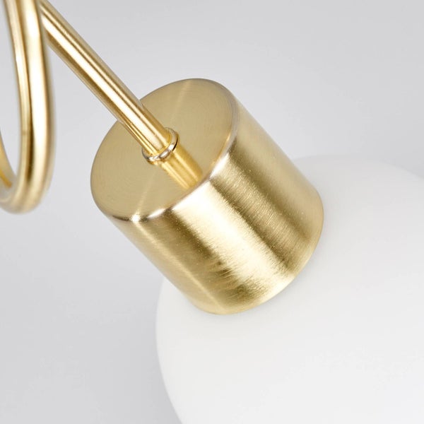 Detailaufnahme einer goldenen Lampenhalterung mit weißem Lampenschirm