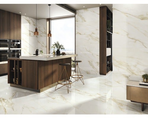 Helle Küche mit Marmorfliesen an Boden und Wänden, Kochinsel und Barhockern.