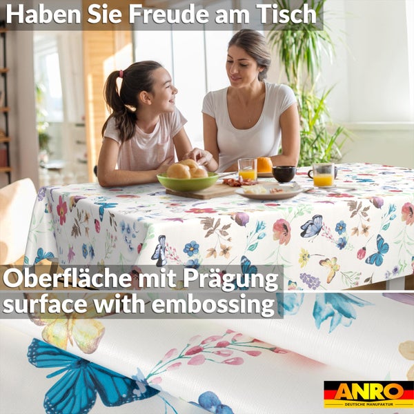 Abwaschbare Tischdecke mit Blumen- und Schmetterlingsmuster auf einem Tisch mit Frühstück, Detailansicht der geprägten Oberfläche, ANRO Logo.