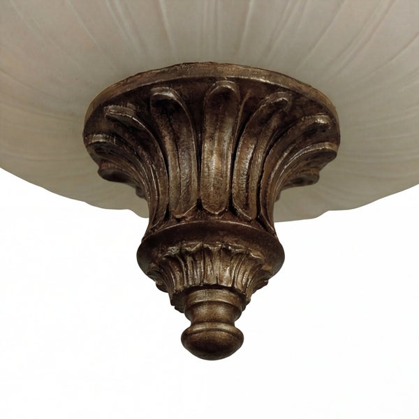 Detail einer verzierten Deckenleuchte im Antik-Stil mit bronzefarbenem Metallelement und Schirm aus satiniertem Glas.