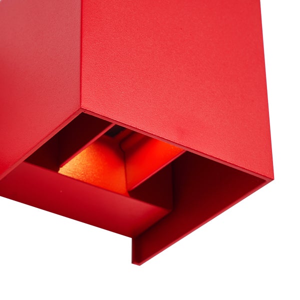 Würfelförmige rote Wandleuchte aus Metall mit strukturierter Oberfläche, Detailansicht von unten mit Lichtaustritt.