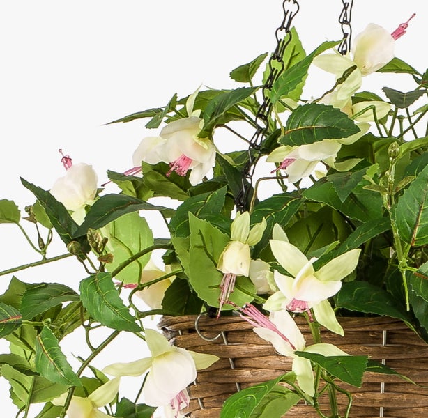 Künstlicher Blütenzweig mit rosa, federartigen Blüten und grünen Blättern.