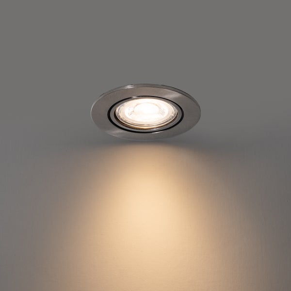 Runder LED-Einbaustrahler aus Metall, eingeschaltet mit warmweißem Lichtschein.