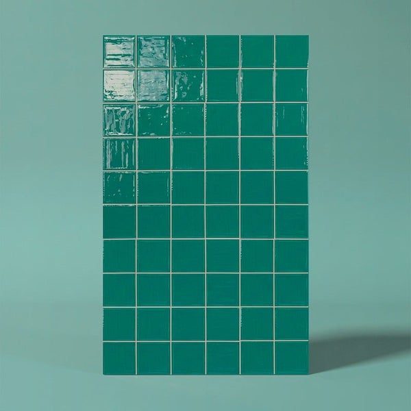 Quadratische Wandfliesen mit glänzender Oberfläche in einem Fliesenverbund angeordnet.