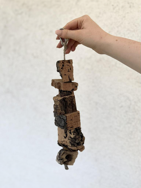 Korkspielzeug für Vögel und Nagetiere zum Aufhängen, bestehend aus mehreren Korkstücken an einer Schnur mit Karabinerhaken.