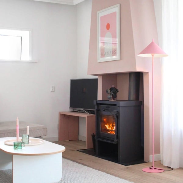 Wohnzimmer mit Kaminofen, Stehlampe und Couchtisch