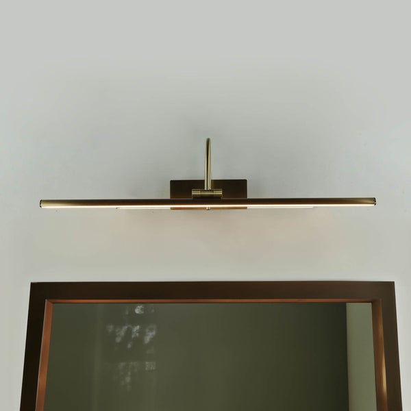 Wandleuchte über einem Spiegel im Badezimmer