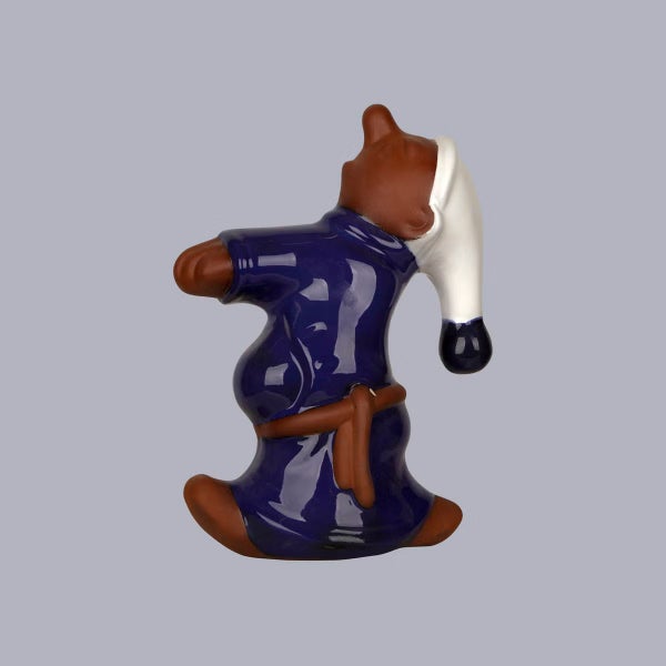 Dekofigur aus Keramik, Darstellung einer Figur in blauem Gewand mit Schlafmütze, Blick nach oben gerichtet.