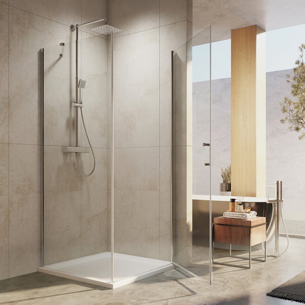 Modernes, helles Badezimmer mit einer Duschkabine aus Glas, flacher Duschwanne, quadratischer Regendusche und Handbrause vor Steinoptik-Wand.