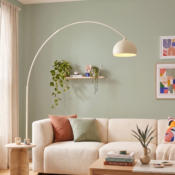 Moderner Wohnraum mit einer Ganzglastür aus Mattglas mit Wellenmotiv, Lounge-Sessel, Stehlampe und grauem Teppich auf Holzboden.