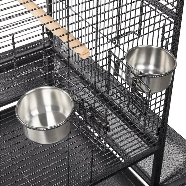 Detailansicht eines Vogelkäfigs mit Futter- und Wassernäpfen sowie einer Sitzstange.