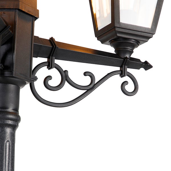 Detailansicht eines klassischen schwarzen Kandelabers mit verzierter Halterung und Laterne.