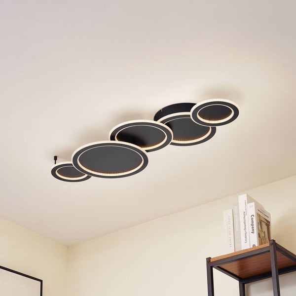 Moderne LED-Deckenleuchte mit fünf überlappenden schwarzen Kreisen und integrierten Leuchtringen an einer weißen Decke.