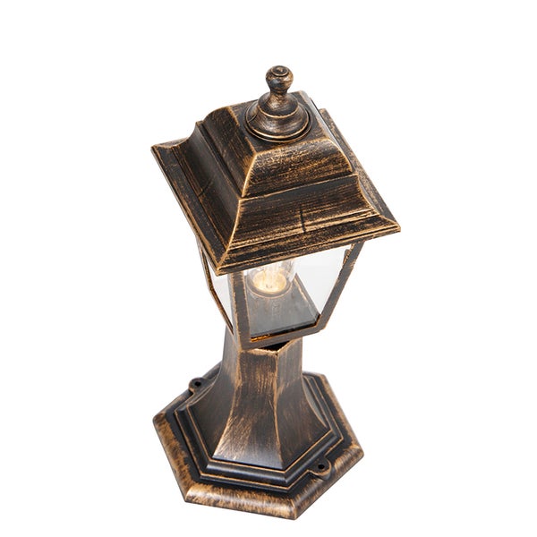 Klassische Außenleuchte als Sockelleuchte in Laternenform aus Metall mit antikem Gold-Finish und klarem Glas.