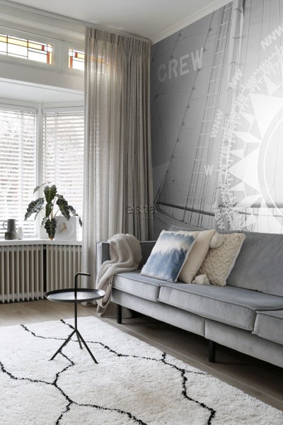 Wohnzimmer mit Sofa, Kissen, Teppich und Fototapete