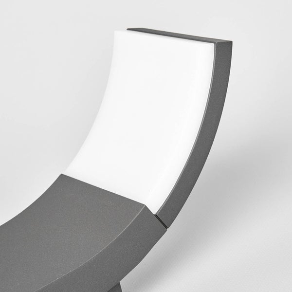 Detail einer gebogenen Außenwandleuchte mit grauem Metallrahmen und weißem Diffusor.