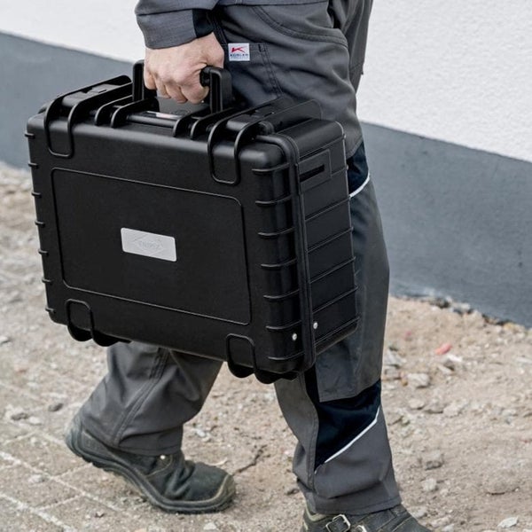 Eine Person trägt einen Werkzeugkoffer.