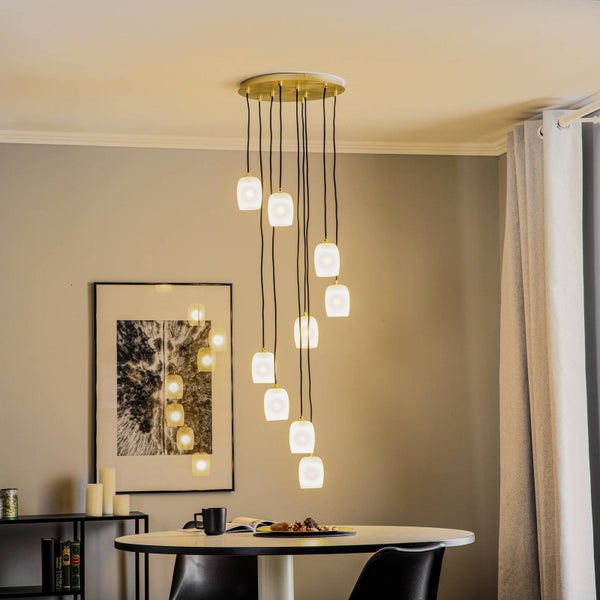 Mehrflammige Pendelleuchte über einem Esstisch mit Dekoration