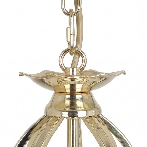 Detailaufnahme einer goldenen Kettenaufhängung für eine Pendelleuchte.