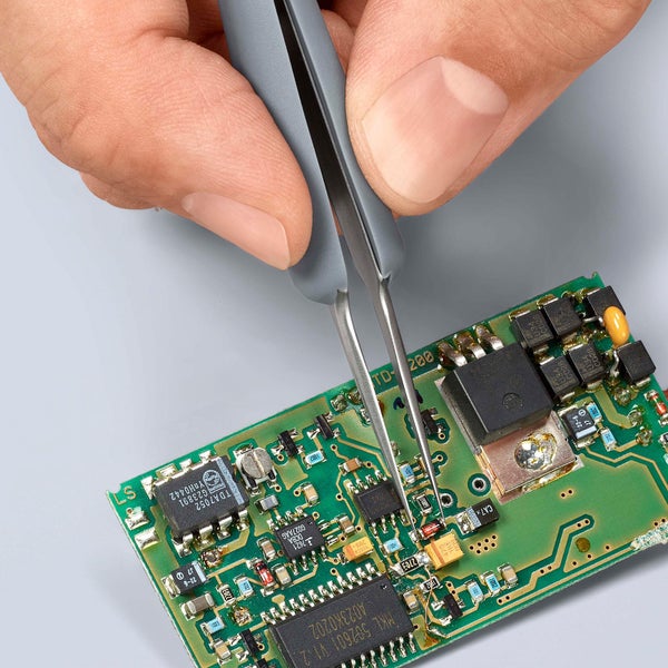 Pinzette auf einer elektronischen Platine für filigrane Arbeiten