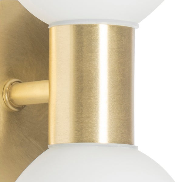 Nahaufnahme einer modernen Wandleuchte mit einem Gehäuse aus gebürstetem goldfarbenem Metall und zwei weißen matten Glaskugeln.