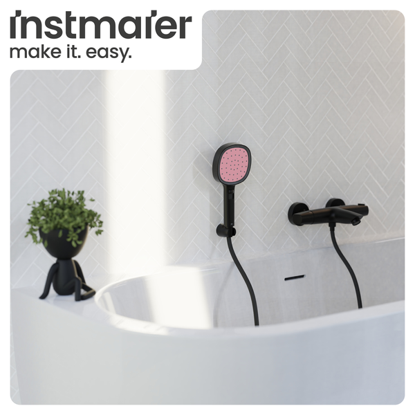 Modernes Badezimmer mit weißer Wanne, schwarzer Wannenarmatur, Handbrause mit rosa Strahlscheibe und Fischgrätenfliesen. Instmaier Logo.