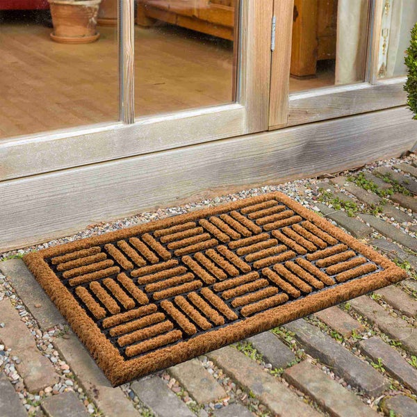 Fußmatte aus Kokosfasern mit rechteckigem Muster vor einer Haustür